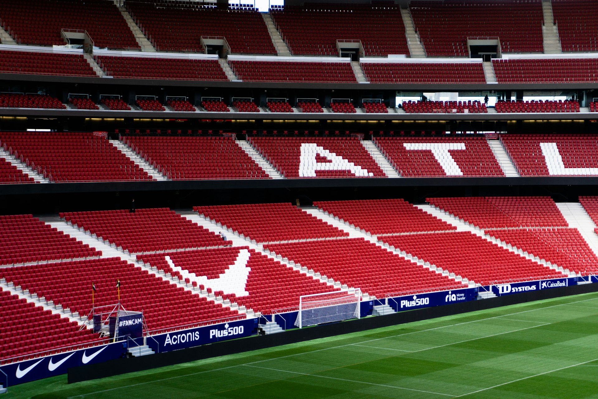 a soccer field with red seats and a green field